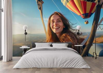 Young woman in a high-altitude hot air balloon , she's in the gondola of a colorful balloon, floating gracefully over picturesque landscapes Wall mural