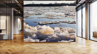 Ice drift on a river with blue high water and big water, white snow broken ice full of hummocks in it and sun reflection in sunny spring day. Wall mural