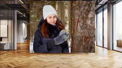 Portrait of a girl in a pine forest on a winter day Wall mural