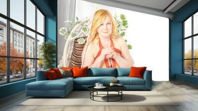 Portrait of Funny cute mature adult woman with blonde hair posing in a swimsuit in a wicker chair with plants. Fat middle-aged lady in underwear in studio. The concept of body positivity and happy Wall mural