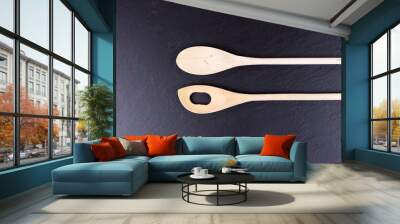 Black slate board for serving with two wooden spoons, top view Wall mural