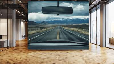 Empty road with mountain views seen through the front windshield of a car. generative ai Wall mural