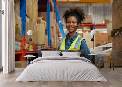 Portrait of female staff smiling with holding clipboard standing in warehouse with looking at camera, Industrial and industrial workers concept. Wall mural