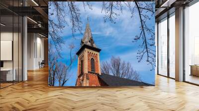 Looking up at a church steeple against a blue sky on a spring day. Wall mural