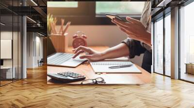 Cropped shot of young businesswoman working on a laptop computer in office at her home. Working at home concept Wall mural