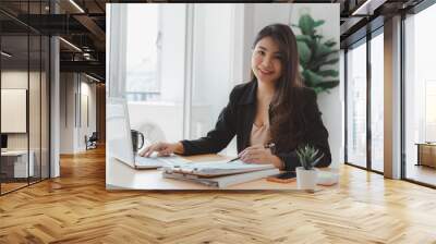 Happy business woman executives discussing financial reports and using laptop in modern bright office indoor. Wall mural