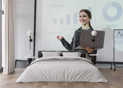 The female Chief Analyst is conducting a meeting presentation for a team of economists. The projector screen shows graphs, product sales, revenue growth strategies, and e-commerce analysis. Wall mural