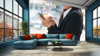 woman in business suit engaged with her smartphone, surrounded by social media notifications. This scene captures modern connection between technology and communication, reflecting busy Wall mural