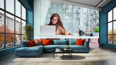 Young asian muslim business woman in smart casual wear discussing business and smiling while sitting in the creative coworking. Wall mural