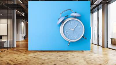 Blue color old fashioned bell alarm clock isolated on blue background Wall mural