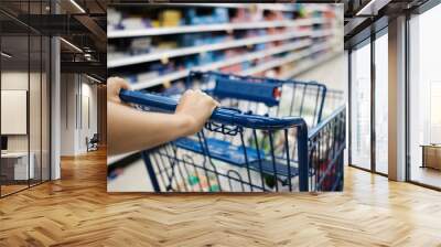 Closeup of woman with blue color shopping cart. Wall mural