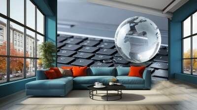 Glass globe on laptop keyboard Wall mural