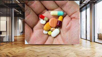 Hand full of large pile of different pills Wall mural