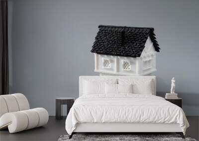 Single miniature 3D printed model house on grey background for home or real estate market Wall mural