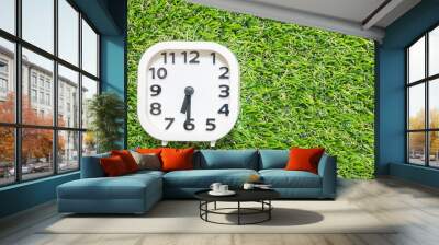 Closeup white clock for decorate show a half past six or 6:30 a.m. on green artificial grass floor textured background with copy space Wall mural