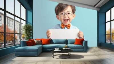 Happy little boy holding a blank sign wearing a bow tie Wall mural