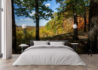 A colorful autumn vista, with trees in many beautiful fall colors of leaves, is viewed from the shade of an Indiana forest in beautiful, scenic Brown County State Park. Wall mural