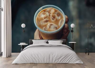 Chilled iced coffee in hand with refreshing ice cubes Wall mural