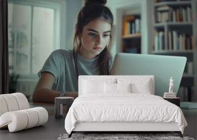 Focused young woman working on laptop in cozy home office setting Wall mural