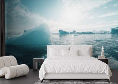 Majestic icebergs floating in tranquil arctic waters under a clear sky Wall mural