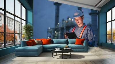 Engineering man working with digital tablet on power plant working site at night time. Wall mural