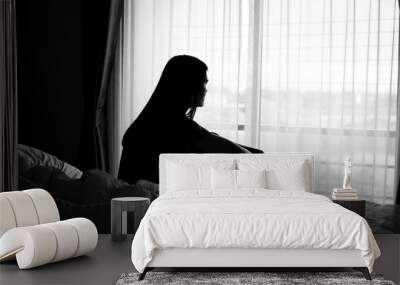 silhouette of alone woman sitting on the bed beside the windows with sunlight in the morning	 Wall mural