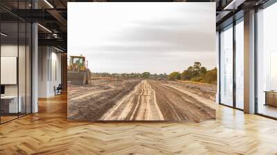 A new road is under construction with several pieces of heavy equipment Wall mural