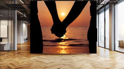 Silhouettes couples holding hands on sunset. Wall mural