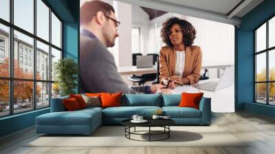 Business colleagues sitting at the desk and having a meeting Wall mural