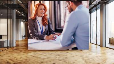 Business people man and woman sitting at the table in the office and signing the contract. Wall mural