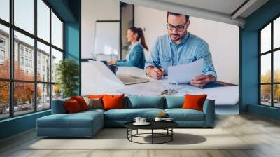 Businessman doing paperwork in the office Wall mural