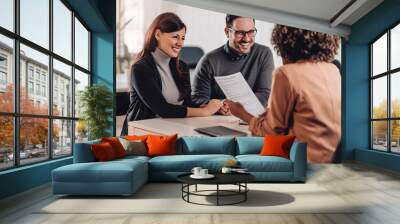 Couple consulting with a female financial manager at the bank Wall mural