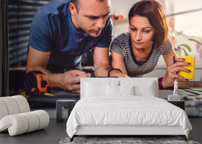 Couple looking at blueprints during kitchen renovation Wall mural