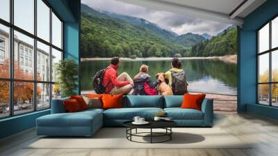 Family with dog resting on a pier Wall mural