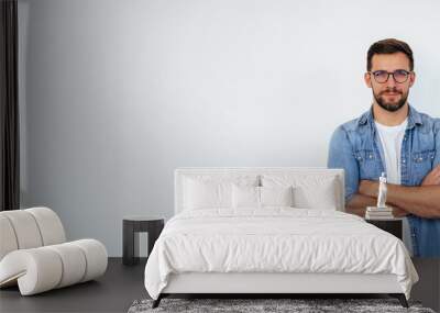 Isolated shot of young handsome man with beard, wearing casual clothes, posing in studio on white background Wall mural