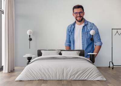 Isolated shot of young handsome man with beard, wearing casual clothes, posing in studio on white background Wall mural