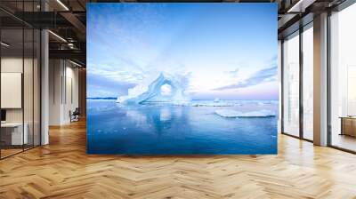 Photogenic and intricate iceberg with a hole under an interesting and colorful sky during sunrise with full moon. Disko bay, Greenland. Wall mural