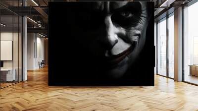 Sinister clown face hidden in the darkness on a dark background. Wall mural