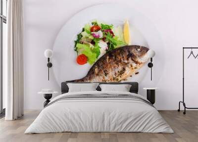 baked whole fish grilled on a plate with vegetables and lemon Wall mural