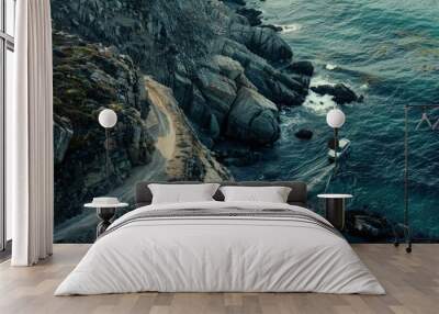 a boat is on the water near a rocky shore Wall mural