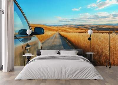 a car driving down a dirt road in the middle of a wheat field Wall mural