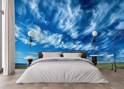 a field with a blue sky filled with clouds Wall mural