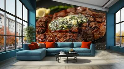 Gourmet ribeye steak topped with rich garlic herb butter elegantly presented on a black plate Wall mural