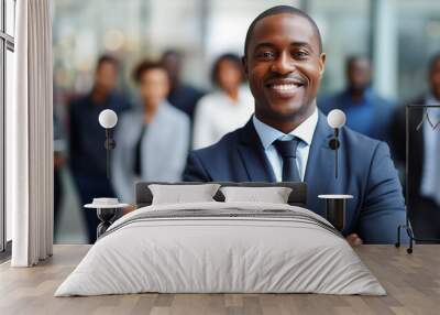 Black businessman smiling with arms crossed, with employees around him Wall mural