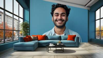 Smiling confident young adult arab man standing isolated on blue background. Happy ethnic guy student or professional employee wearing shirt looking at camera posing, Generative AI Wall mural