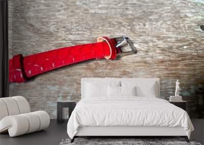 Red leather strap of wristwatch on wooden background. Wall mural