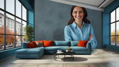 Happy young smiling confident professional business woman wearing blue shirt, pretty stylish female executive looking at camera, standing arms crossed isolated on gray background Wall mural