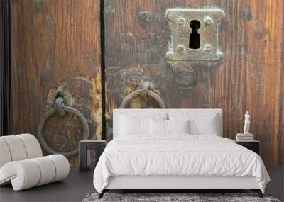 Two rusty iron ring door knobs and keyhole over an old wooden grunge door Wall mural