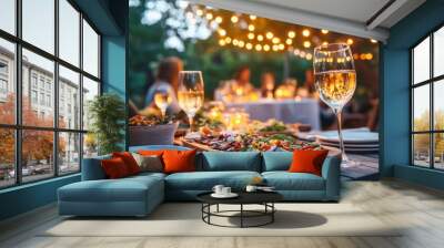 A cozy, intimate outdoor dinner party at sunset, with food, wine glasses, and a colorful salad Wall mural