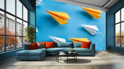 Paper planes fly in one direction while an individual points in a different way, representing new ideas and innovation in business. Wall mural